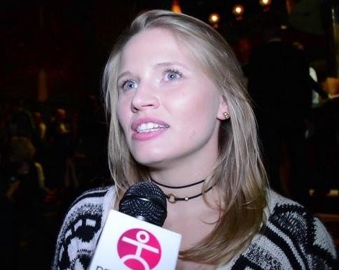 Natalia Rybicka na scenie teatralnej, uchwycona w dynamicznej pozie, z teatralnym oświetleniem podkreślającym jej artystyczną ekspresję.