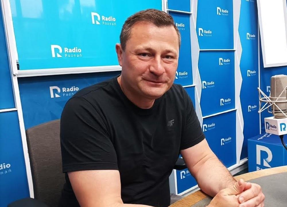 Krzysztof Paszyk przeglądający Instagram na telefonie komórkowym, w naturalnej, codziennej scenerii.