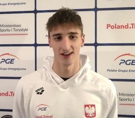 Ksawery Masiuk podczas dynamicznego kopnięcia w stylu grzbietowym pod wodą, ukazujące siłę i precyzję ruchu jego nóg.