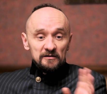 Jan Klata, polski reżyser teatralny, w ujęciu średnim, intensywnie spoglądający, prawdopodobnie w trakcie próby lub na zapleczu teatru.