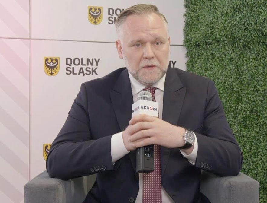 Scena z obrad polskiego Sejmu, przedstawiająca wnętrze sali plenarnej i polityków w trakcie sesji parlamentarnej.