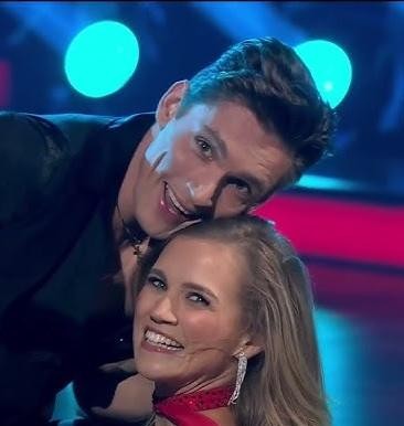 Agnieszka Kaczorowska w dynamicznej pozie tanecznej, prezentująca grację i umiejętności.