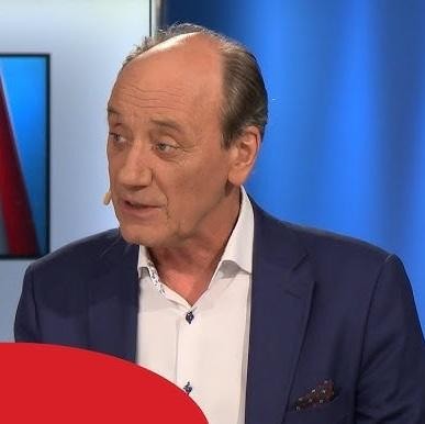 Dariusz Szpakowski w ferworze komentowania meczu, z charakterystyczną ekspresją i mikrofonem, symbolizujący jego pasję i zaangażowanie w relacjonowanie sportu.