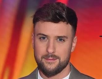 Aleksander Sikora, prezenter telewizyjny, w swobodnej interakcji z ludźmi, uśmiechnięty i przystępny.