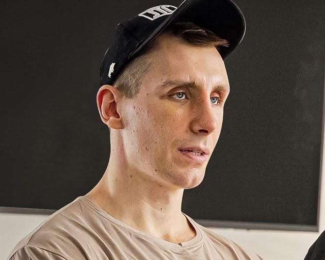 Alt: Michał Owczarzak (Owca WK) uśmiechnięty i pozujący w siłowni, prezentujący swoją umięśnioną sylwetkę, jako symbol inspiracji fitness.