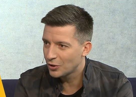 Michał Cessanis korzystający z telefonu, z elementami podróży i mediów społecznościowych w tle, symbolizujący jego aktywność na Instagramie.