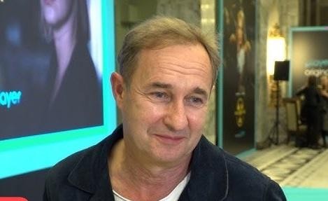 Marek Kalita w roli reżysera, z zaangażowaniem pracujący na planie teatralnym, oddający atmosferę twórczego procesu.