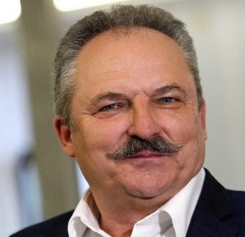 Marek Jakubiak podczas wystąpienia publicznego, z widoczną publicznością w tle.