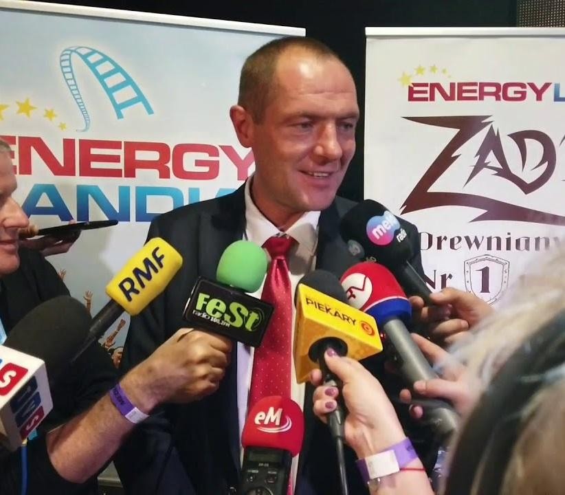 Marek Goczał prowadzący samochód rajdowy klasy SSV na piaszczystym torze, z kurzem unoszącym się za pojazdem, symbolizujący jego pasję do rajdów terenowych.