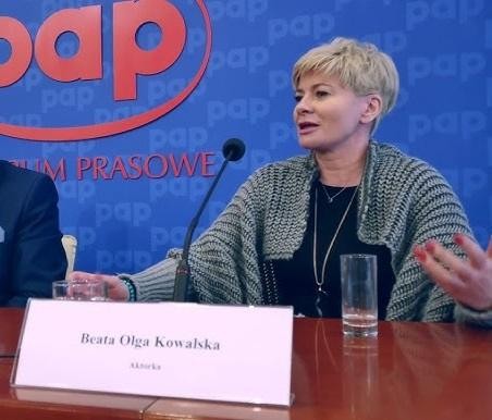 Beata Olga Kowalska na scenie teatralnej podczas występu, w dynamicznej pozie, oddającej pasję i energię aktorstwa.